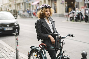 Woman with bicycle in the city, Berlin, Germany - AHSF01346