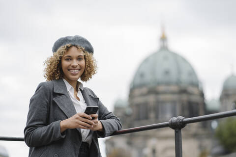 Portrait of happy tourist woman in the city with Berlin Cathedral in background, Berlin, Germany stock photo