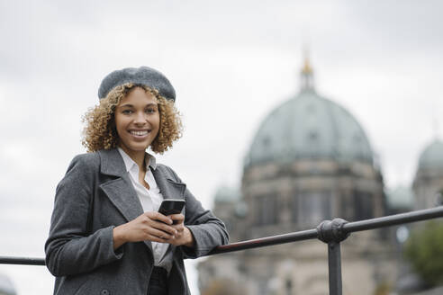 Portrait of happy tourist woman in the city with Berlin Cathedral in background, Berlin, Germany - AHSF01352