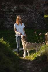 Yound woman with her dog outdoors - MAUF03088