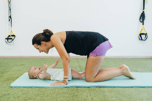 Junge Mutter und Baby beim Üben auf der Yogamatte - MPPF00275