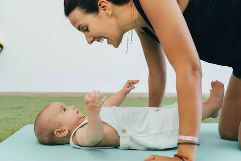 Junge Mutter und Baby beim Üben auf der Yogamatte - MPPF00276