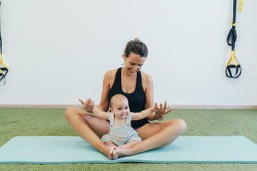 Young mother and baby exercising on yoga mat - MPPF00277