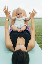 Junge Mutter und Baby beim Üben auf der Yogamatte - MPPF00282
