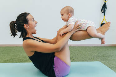 Young mother and baby exercising on yoga mat - MPPF00288