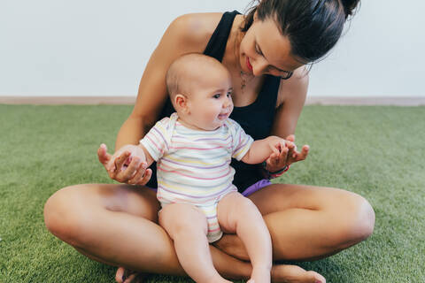 Junge Mutter und Baby beim Mutter-Kind-Turnen, lizenzfreies Stockfoto