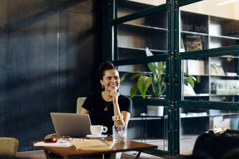 Happy casual young businesswoman with laptop in loft office stock photo