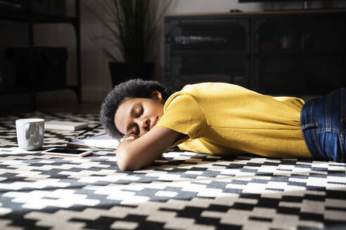 Young woman lying on the floor at home with closed eyes - GIOF07783