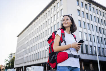 Junge Rucksacktouristin mit Smartphone in der Stadt, Verona, Italien - GIOF07877