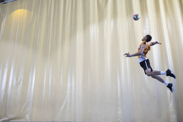 Man jumping during a volleyball match to start a game - ABZF02845