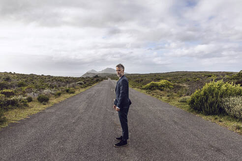 Geschäftsmann auf der Landstraße stehend, Cape Point, Westkap, Südafrika - MCF00332