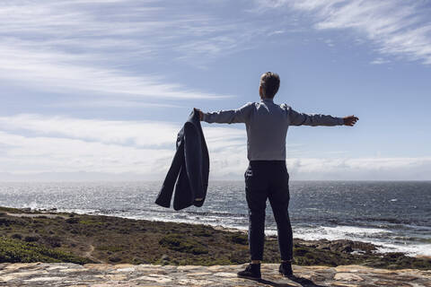 Rückenansicht eines Geschäftsmannes, der vor dem Meer steht, Cape Point, Westkap, Südafrika, lizenzfreies Stockfoto