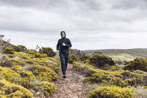 Man jogging in rural scene, Cape Point, Western Cape, South Africa - MCF00346