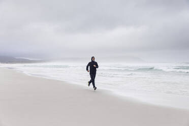 Mann joggt am Strand, Nordhoek, Westkap, Südafrika - MCF00356