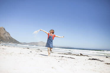 Girl listening music with headphones, dancing on the beach, Cape Town, Western Cape, South Africa - MCF00364