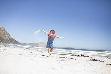 Mädchen hört Musik mit Kopfhörern und tanzt am Strand, Kapstadt, Westkap, Südafrika - MCF00364