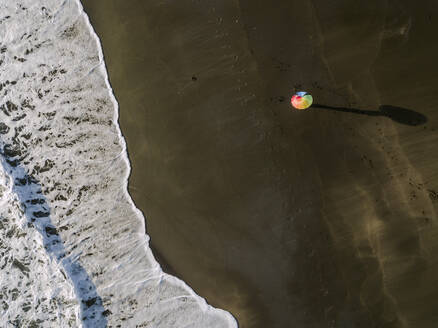 Luftaufnahme von Regenbogenfarben Regenschirm am Strand, Kedungu Strand, Bali, Indonesien - KNTF03733