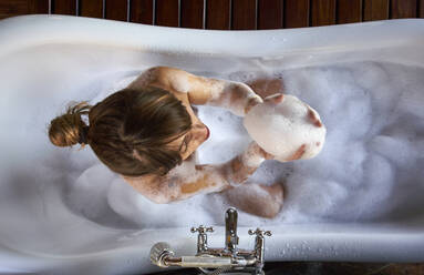 Frau spielt mit dem Schaum in einer Badewanne, von oben - VEGF00835