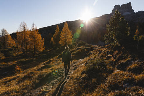 Rear view of female hiker hiking at Dolomites Alps, Cortina, Italy - MRAF00426