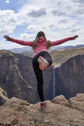 Wanderin balanciert auf dem Gipfel eines Hügels, Maletsunyane Falls, Lesotho - VEGF00840