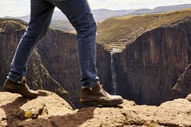 Tiefschnitt eines Mannes, der durch die Berge wandert, Maletsunyane Falls, Lesotho - VEGF00841