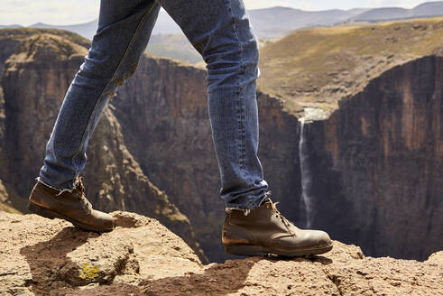 Tiefschnitt eines Mannes, der durch die Berge wandert, Maletsunyane Falls, Lesotho - VEGF00842