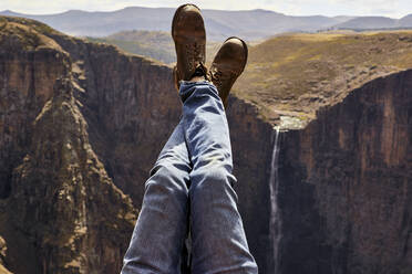 Low section of a man with legs up in the mountains, Maletsunyane Falls, Lesotho - VEGF00844