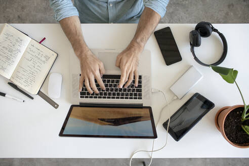 Top view of man using laptop at desk in office - VPIF01784