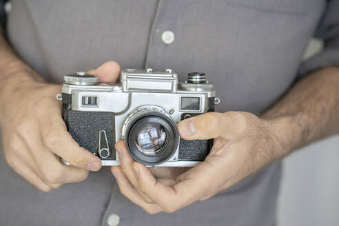 Close-up of man holding old-fashioned camera - VPIF01813