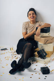 Portrait of young woman dressed for a party, celebrating Christmas with gifts and champagne - MPPF00305