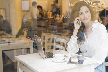 Frau am Telefon in einem Cafe - FMOF00762