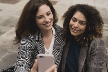 Two smiling women taking a selfie outdoors - FMOF00773