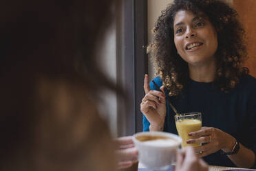 Zwei Frauen treffen und unterhalten sich in einem Café - FMOF00803