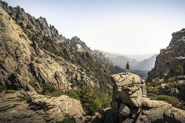 Female hiker standing on viewpoint, Aiguilles de Bavella, Corsica, France - MSUF00009