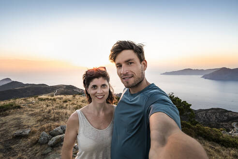 Paar macht ein Selfie bei Sonnenuntergang, Belvedere de Saliccio, Piana, Corse-du-Sud, Korsika, Frankreich - MSUF00019