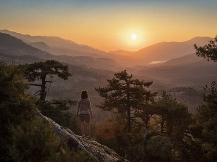 Female hiker standing on viewpoint, Albertacce, Lac de Calacuccia at sunrise, Haute-Corse, Corsica, France - MSUF00036