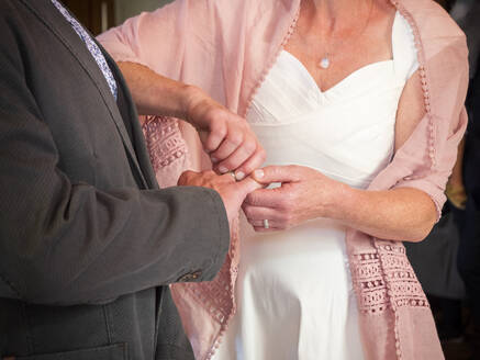 Braut steckt Ehering an den Finger des Bräutigams - LAF02427