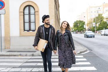 Portrait of happy young couple crossing the street - ERRF02160