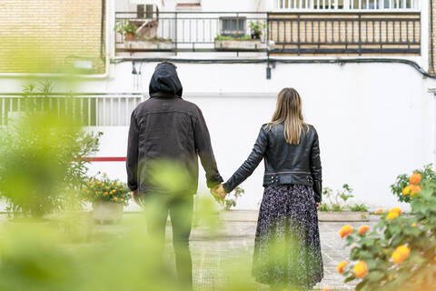 Rückenansicht eines jungen Paares Hand in Hand, lizenzfreies Stockfoto