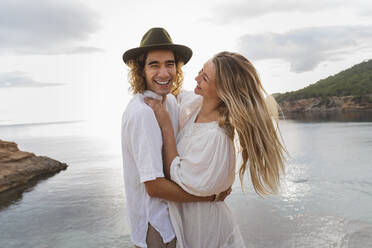 Portrait of young couple in love standing in front of the sea, Ibiza, Balearic Islands, Spain - AFVF04256