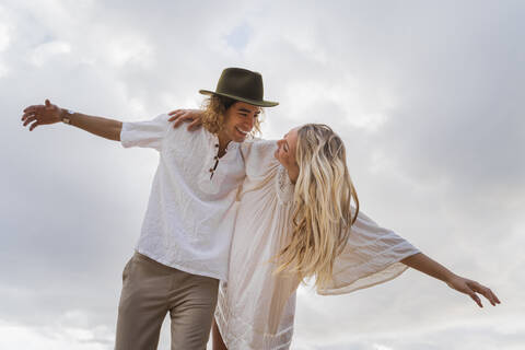 Glückliches junges Paar gegen den Himmel, lizenzfreies Stockfoto