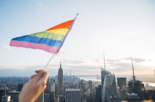 Hand schwenkt LGBT-Flagge in NYC, USA - JCMF00295