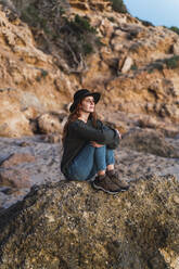 Junge Frau sitzt am Strand und genießt den Sonnenuntergang, Ibiza - AFVF04295