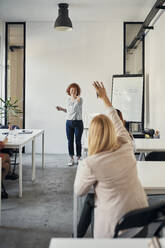 Geschäftsfrau hebt ihre Hand während eines Workshops im Konferenzraum - ZEDF02706