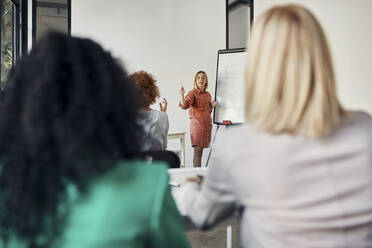 Geschäftsfrau führt eine Präsentation am Flipchart im Konferenzraum durch - ZEDF02722