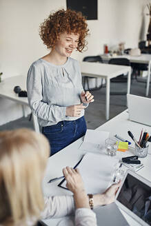Smiling businesswoman leading a meeting in office - ZEDF02736