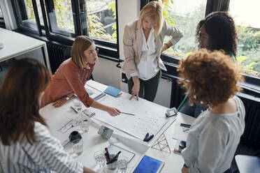 Geschäftsfrauen mit einer Sitzung im Büro mit Blaupausen auf dem Tisch - ZEDF02761