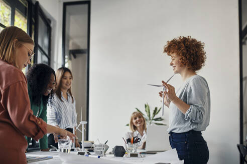 Geschäftsfrauen bei einer Besprechung im Büro mit Windradmodellen - ZEDF02764