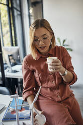 Geschäftsfrau bei einer Kaffeepause im Büro - ZEDF02775