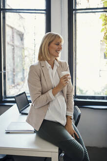 Schwangere Geschäftsfrau bei einer Kaffeepause im Büro - ZEDF02787